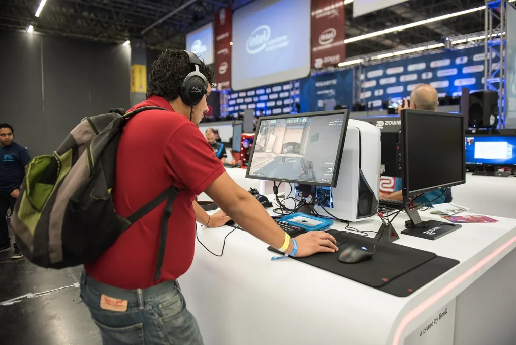 Visitor trying out a gaming PC with a headset at Campus Party