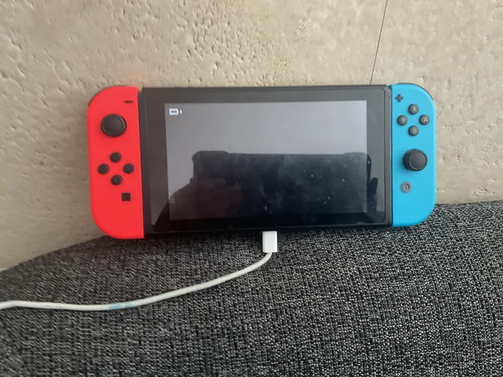 Original Nintendo Switch in handheld mode while charging