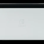 Nintendo Switch OLED model in its dock with Joy-Con controllers