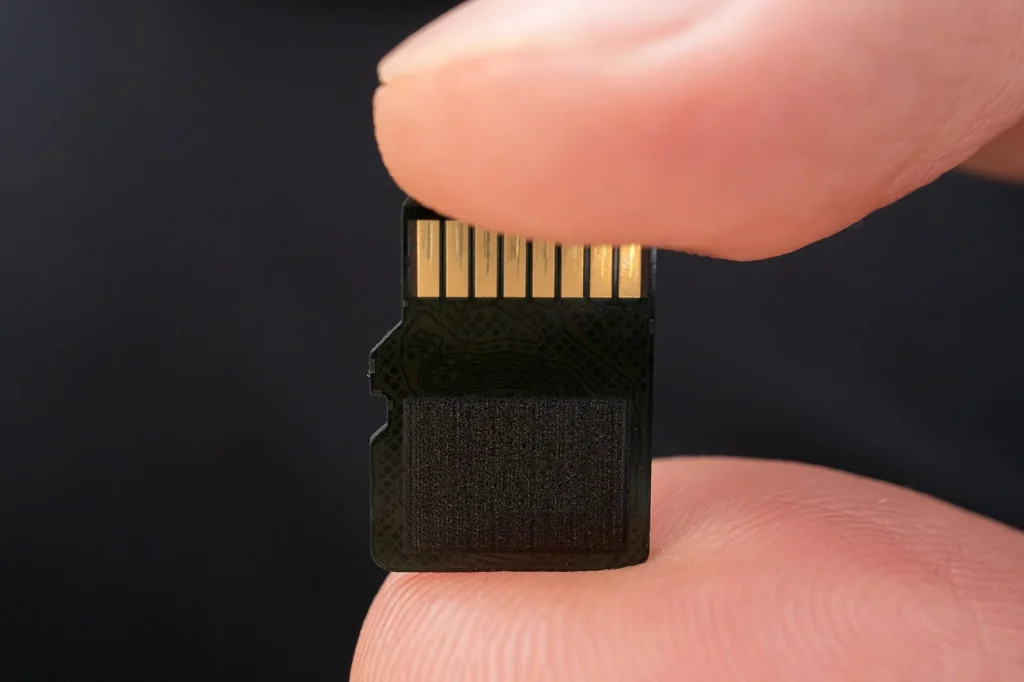 A microSD card held between two fingers