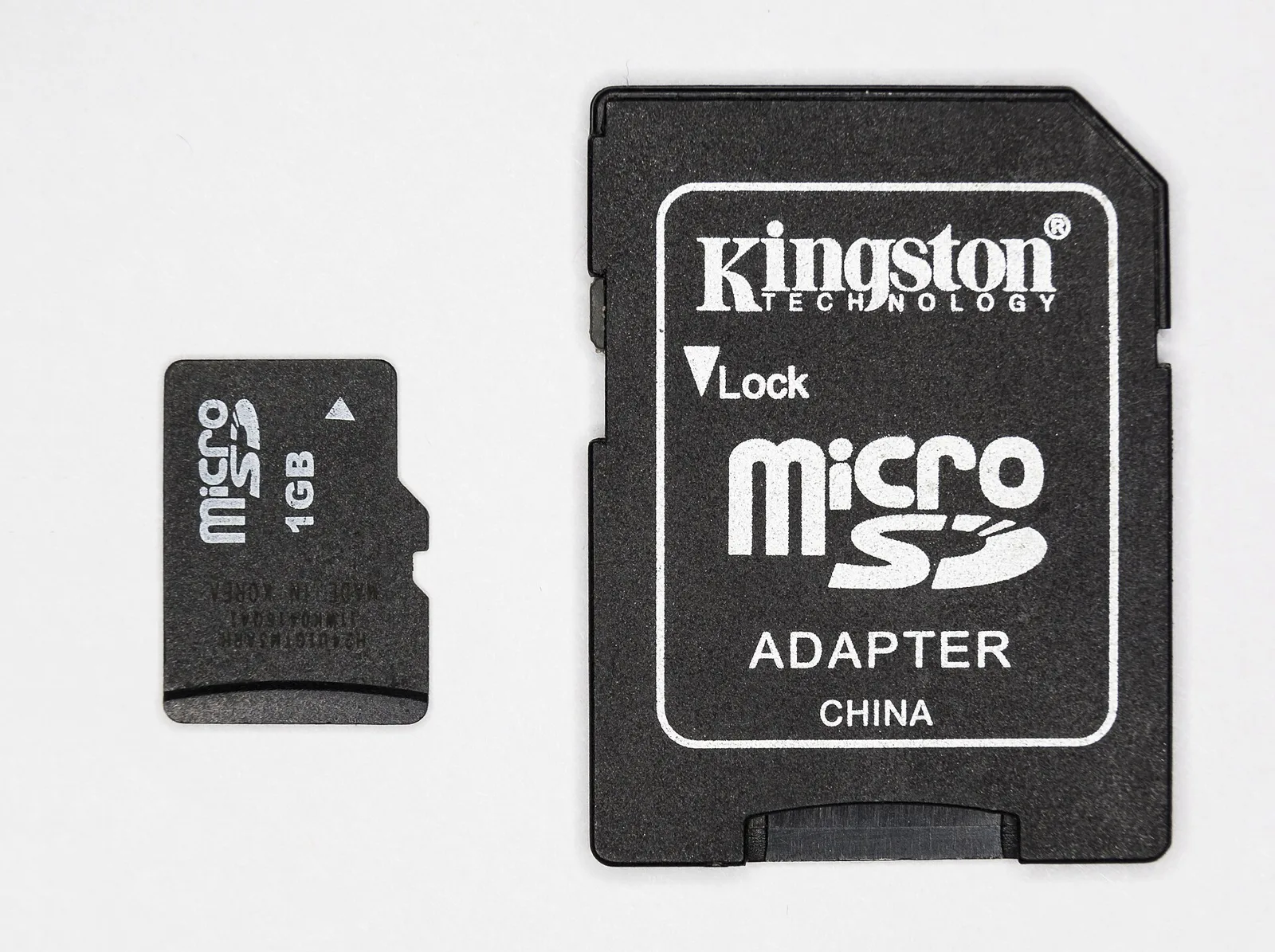 microSD card next to a full-size SD adapter